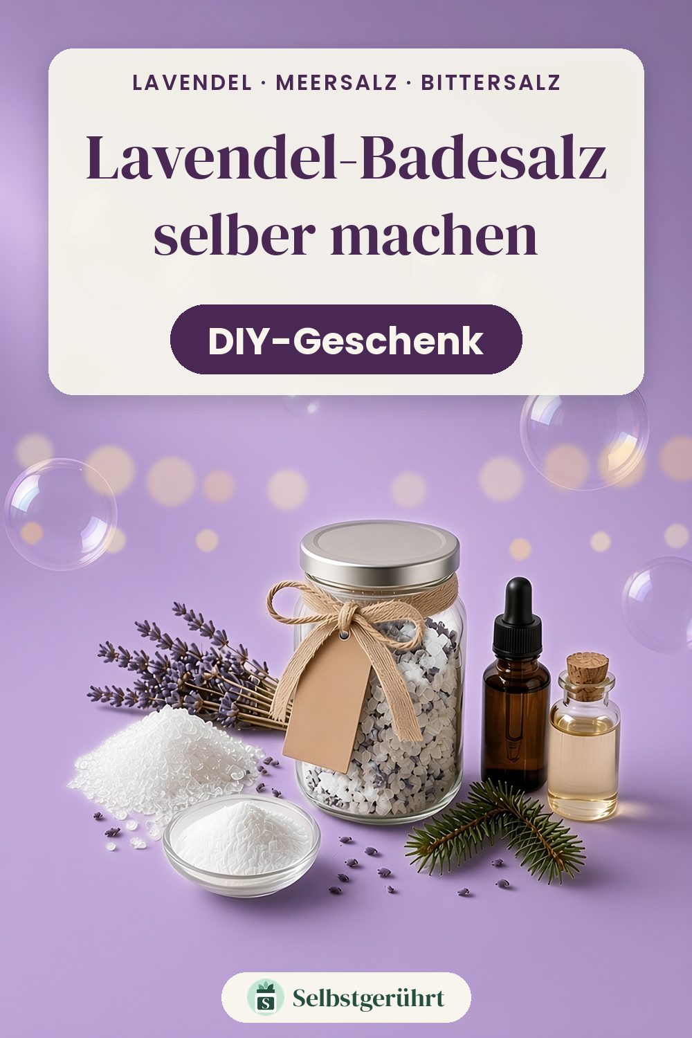 Schraubglas mit Lavendel-Badesalz, Juteschleife und Kraftpapier-Anhänger auf lila Hintergrund, daneben Lavendelzweige, ein Häufchen Meersalz, ein Schälchen Natron, ein Fläschchen Lavendelöl, ein Fläschchen Mandelöl und ein Tannenzweig. Oben steht „Lavendel-Badesalz selber machen – DIY-Geschenk“.